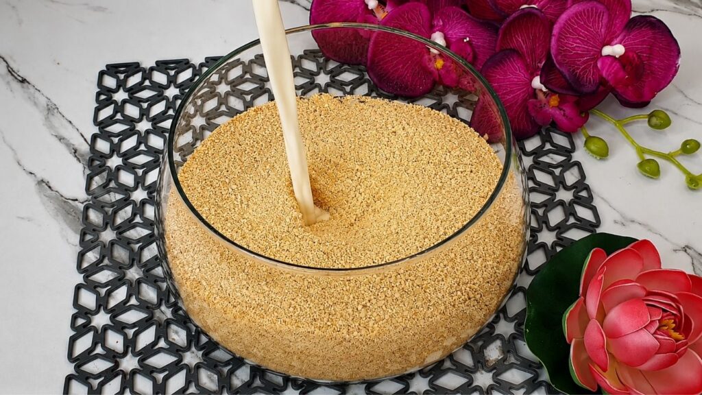 Bowl of crushed graham crackers mixed with milk sugar and vanilla for no bake raspberry yogurt cake crust recipe