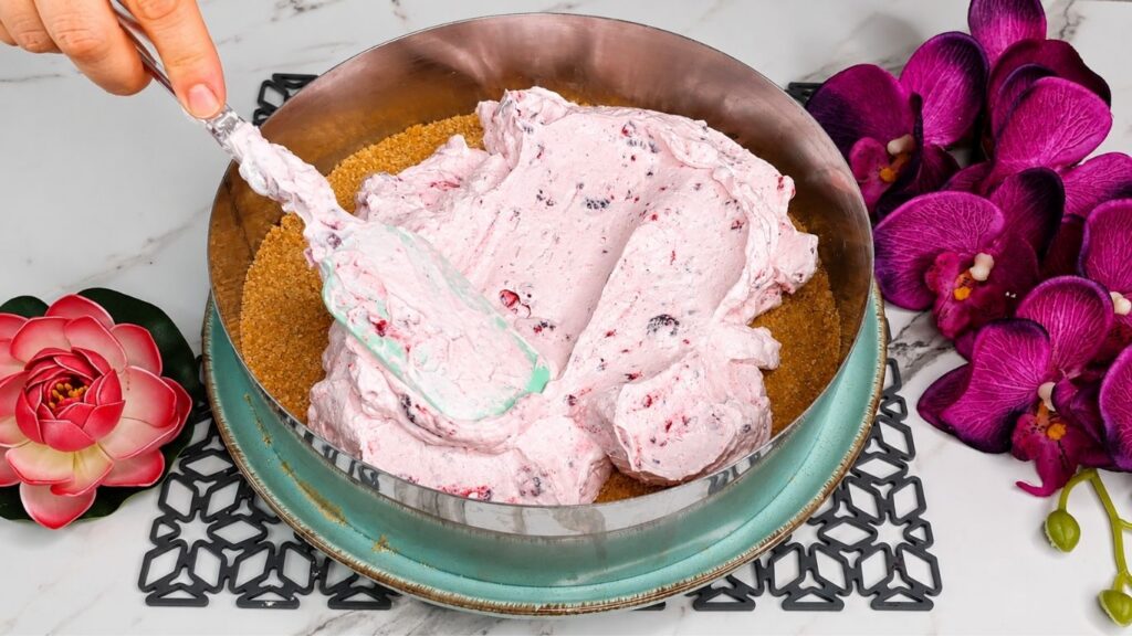 Whipping heavy cream and mixing with yogurt and ingredients for easy no bake raspberry yogurt cake filling