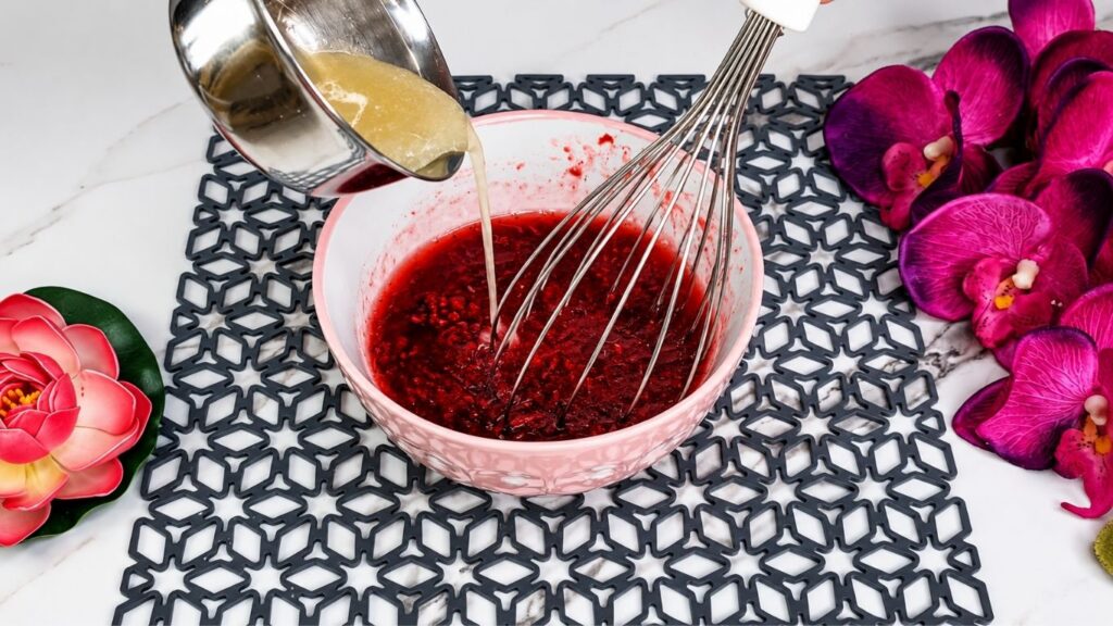 Crushing fresh raspberries with sugar and water for easy no bake raspberry yogurt cake glaze topping