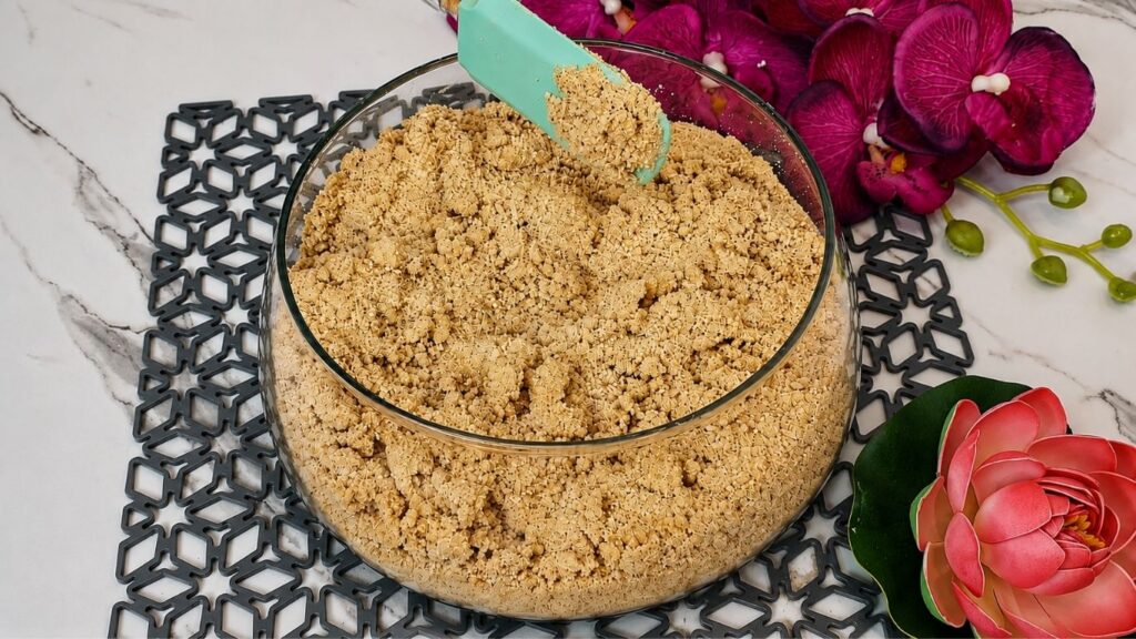 Mixing crushed graham crackers with milk and sugar for no bake raspberry yogurt cake recipe crust base