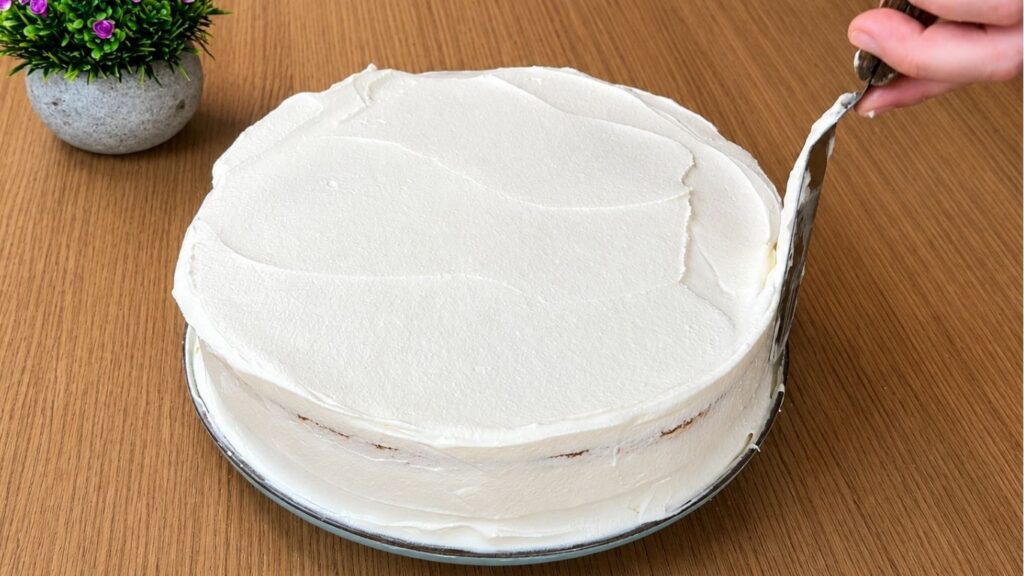 Covering the easy strawberry cake with smooth vanilla cream before final decoration
