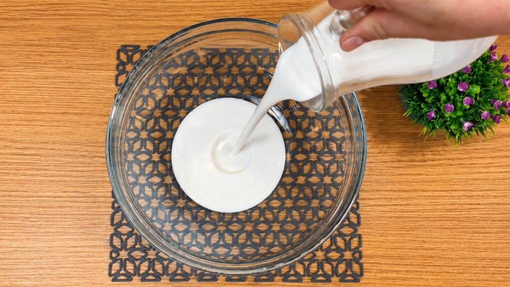Whipping heavy cream until it becomes light and fluffy and holds stiff peaks for decorating the no-bake strawberry yogurt cake