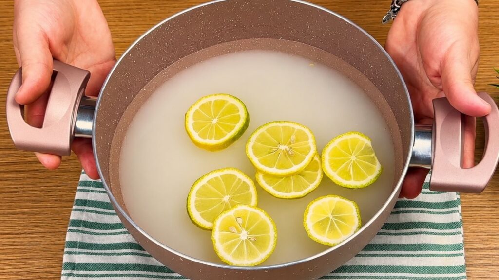 Sugar, water, and lemon slices in a saucepan for homemade baklava syrup.