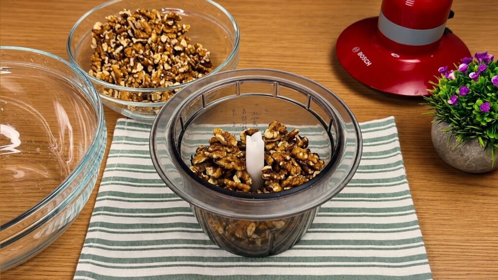 Walnuts in a food processor for homemade baklava recipe filling.