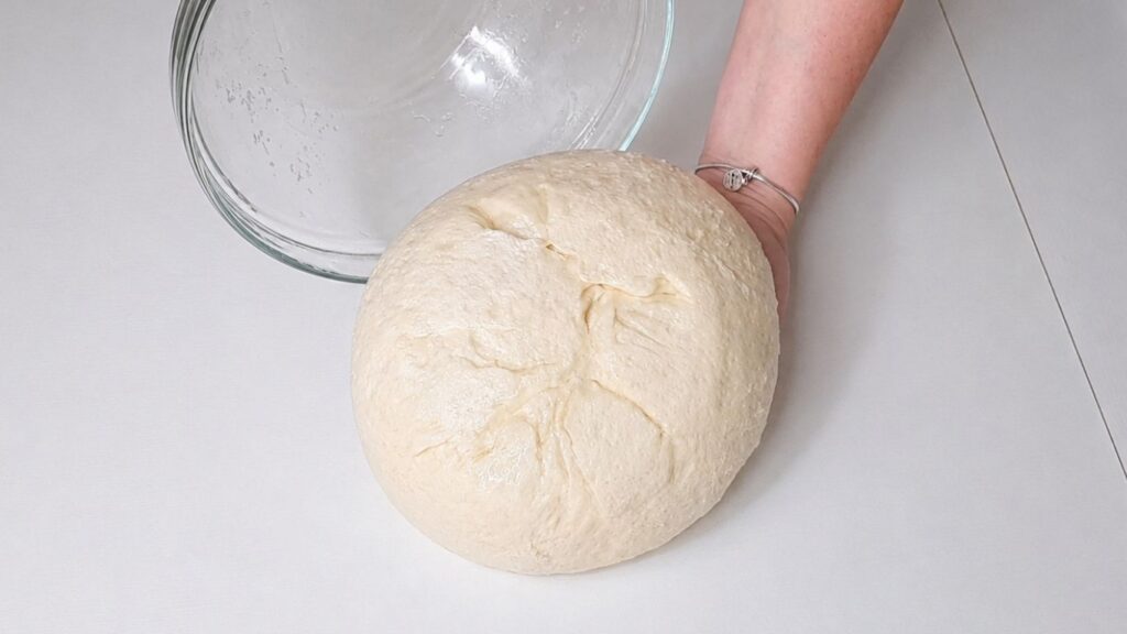 Risen dough placed on a work surface before shaping the Christmas bread wreath.