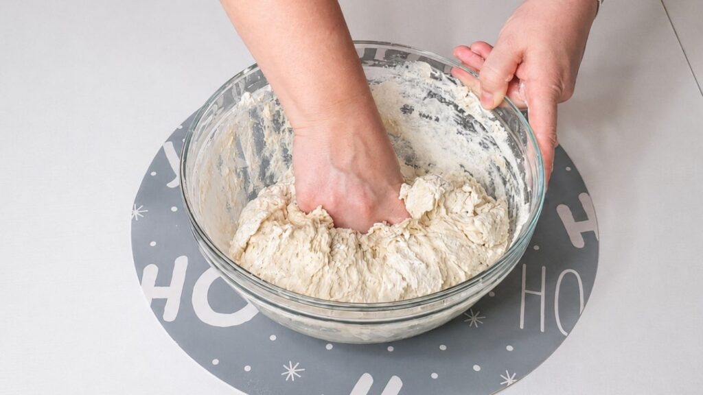 Mixing soft dough in a bowl and kneading it on a work surface.