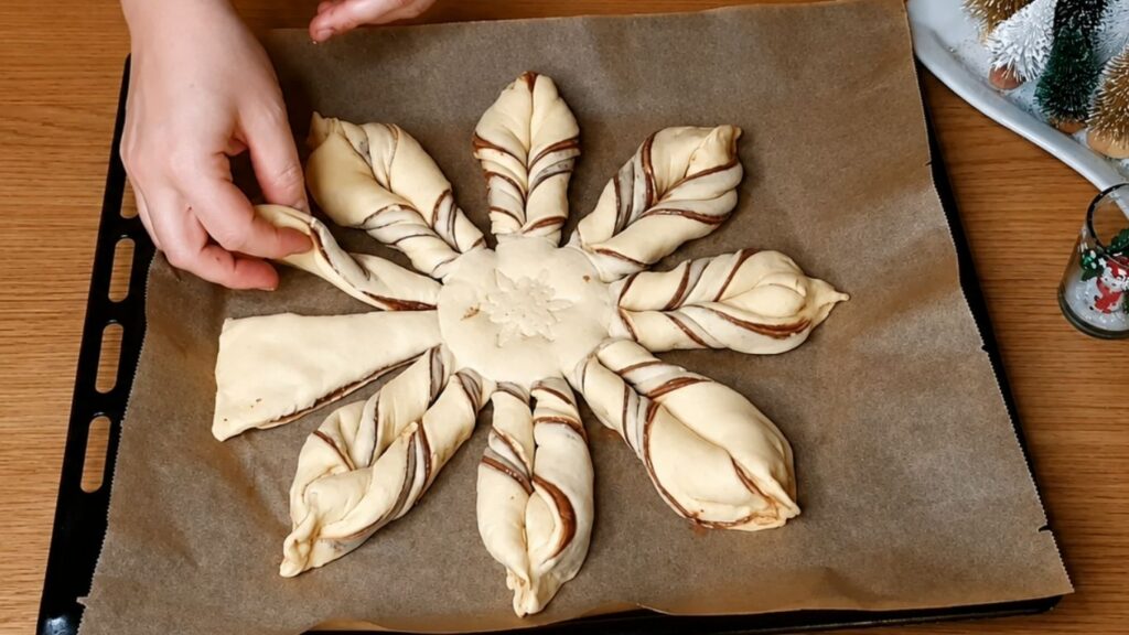 Unbaked chocolate star bread on a parchment-lined baking sheet, brushed with egg wash and ready for the oven.