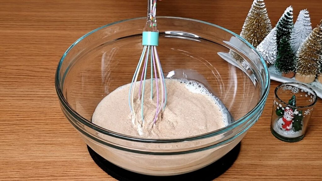 Adding yeast to lukewarm milk to prepare the dough for chocolate star bread.
