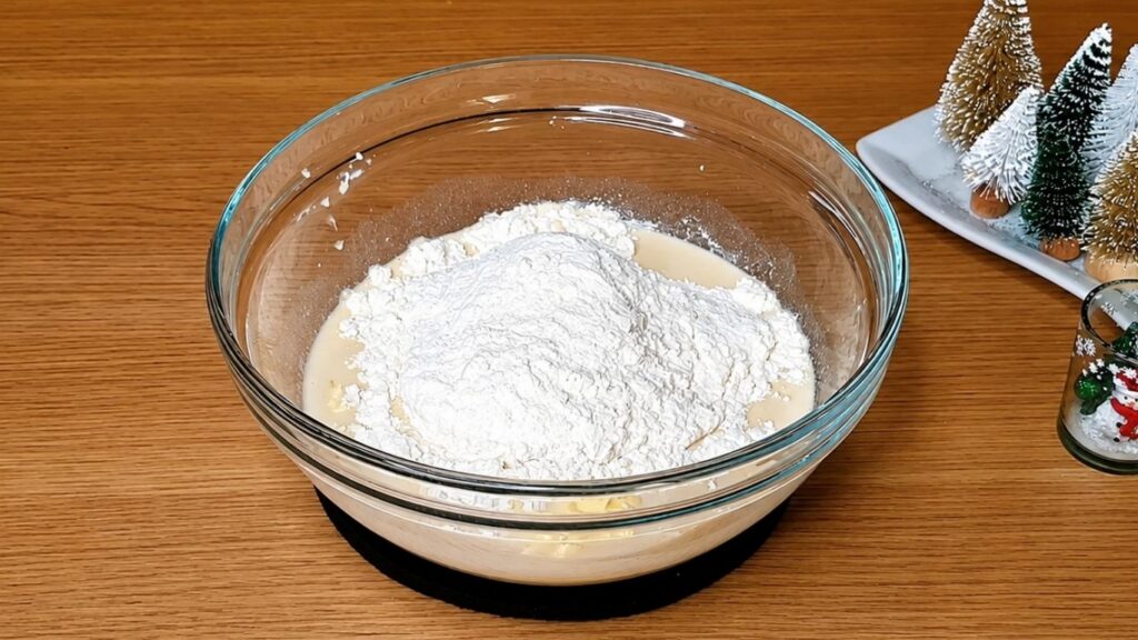 Adding flour gradually to the yeast mixture to make soft dough for homemade chocolate star bread.