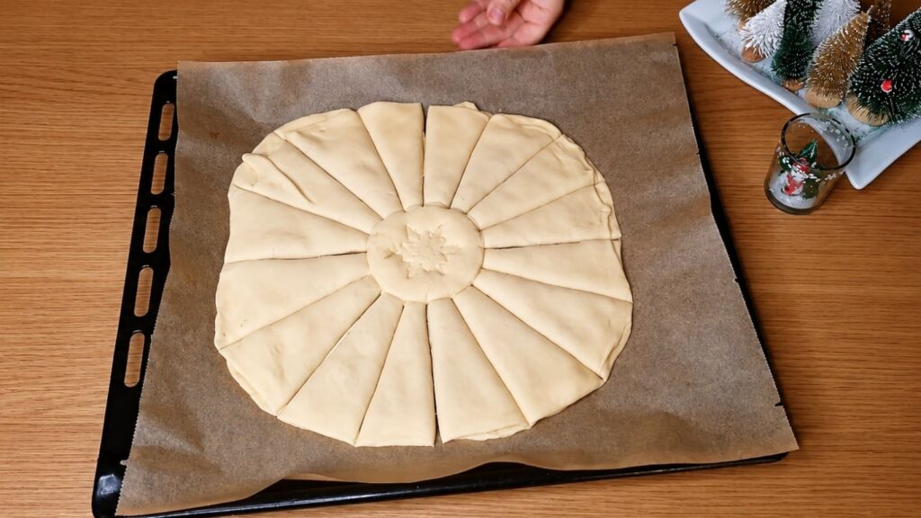 Chocolate star bread dough cut into 16 equal strips before twisting into a star shape.