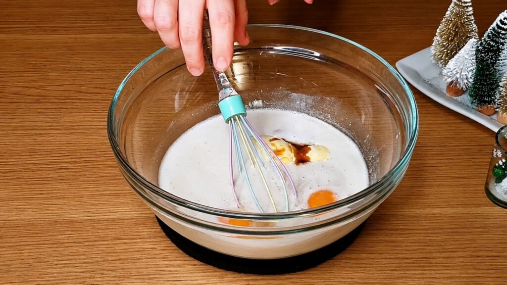 Adding the remaining dough ingredients to the activated yeast mixture for homemade chocolate star bread.