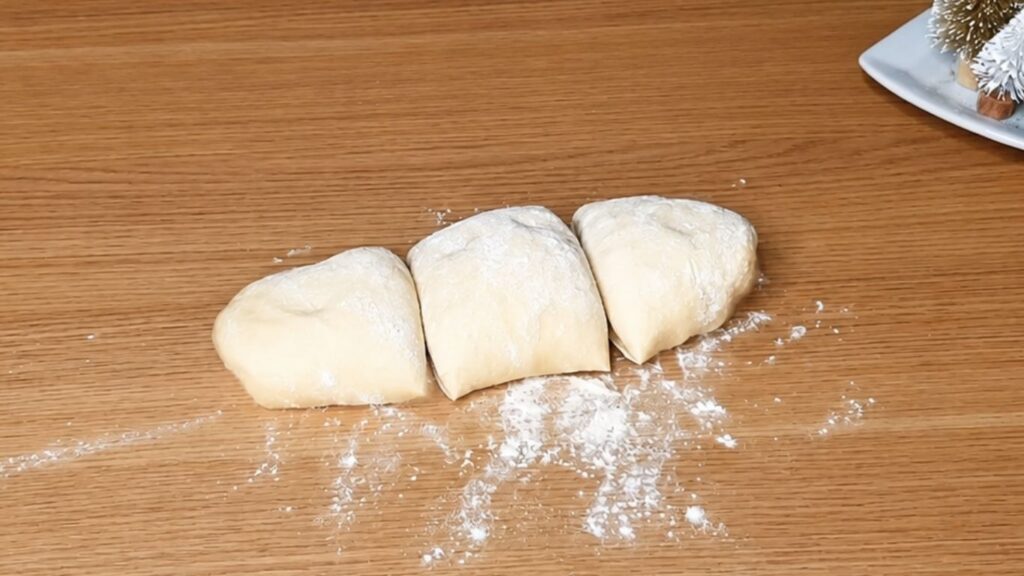 Chocolate star bread dough divided into three equal pieces before rolling and filling.
