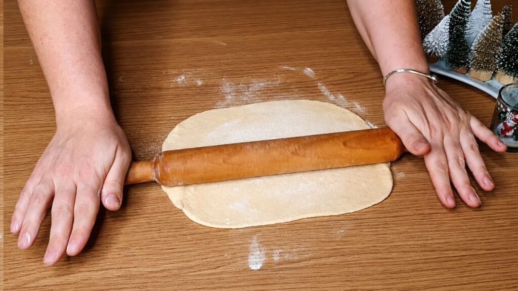 Rolling out the chocolate star bread dough with a rolling pin into a thin, even circle.
