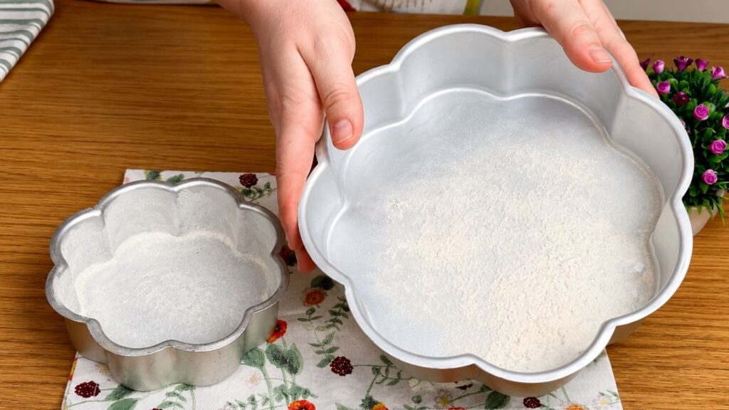 Greased and floured cake pan prepared for baking a moist chocolate sponge cake without sticking.