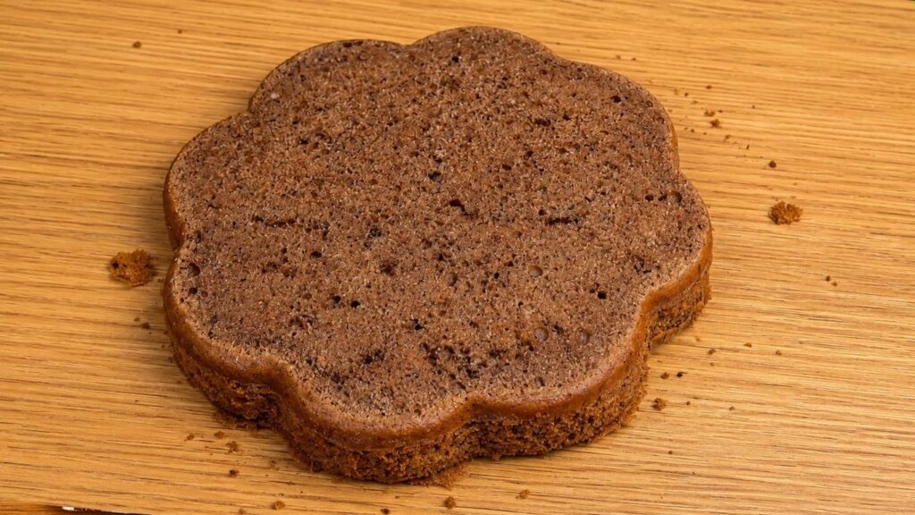 Sliced chocolate sponge cake layer showing a soft, moist, and fluffy texture, perfect for filling and stacking.
