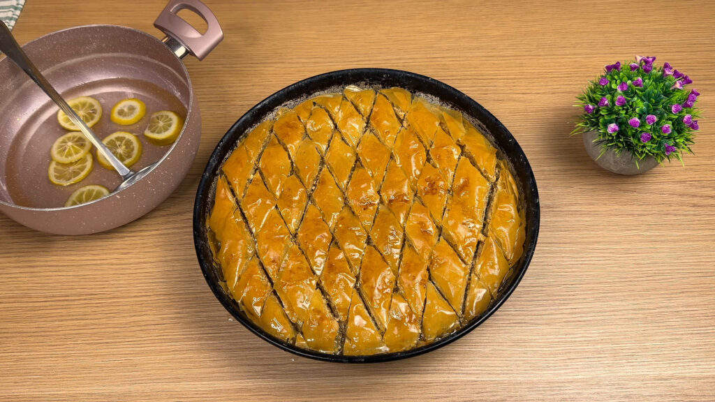 Pouring hot syrup over freshly baked baklava for a crispy and juicy baklava recipe.