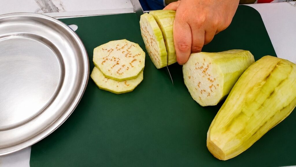 Breaking apart a breaded eggplant slice to show its soft and tender center.