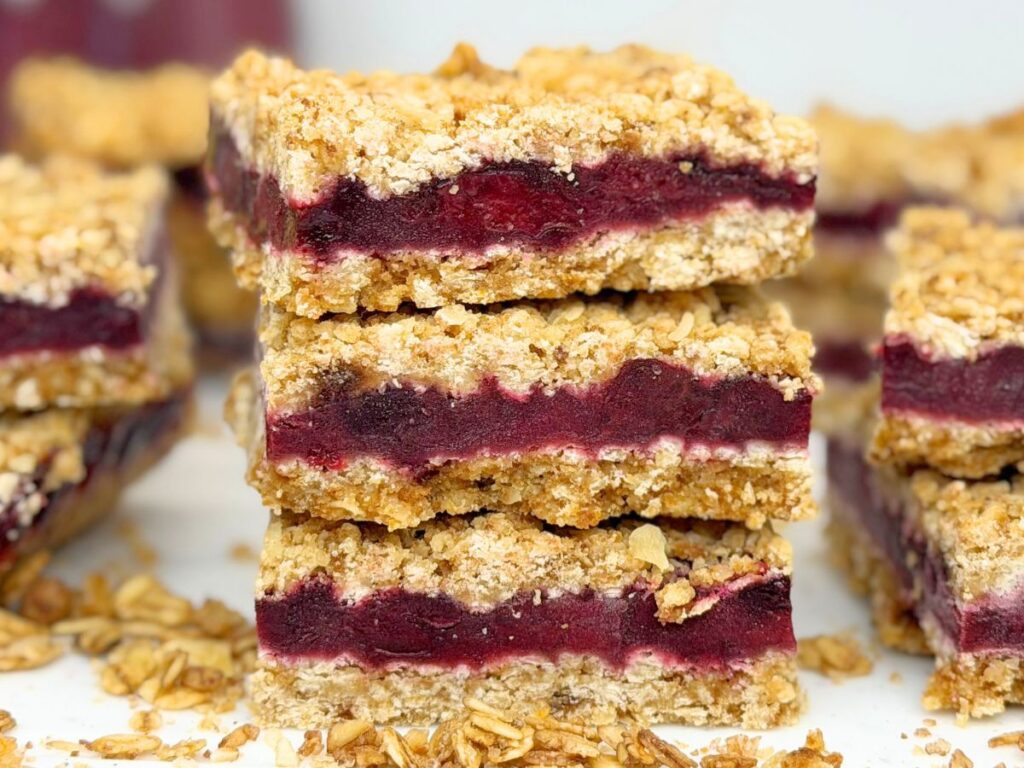 Three stacked cherry crumb bars with a thick cherry filling and golden oat crumble topping.