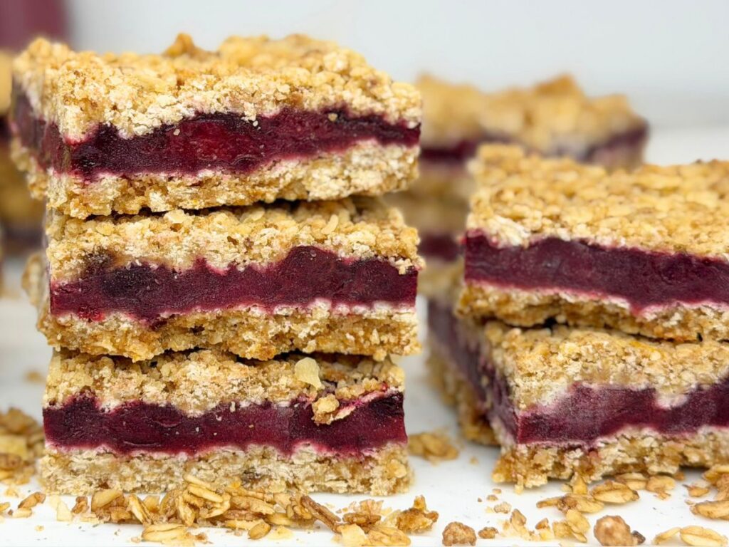 Three stacked cherry crumb bars with a thick cherry filling and golden oat crumble topping.