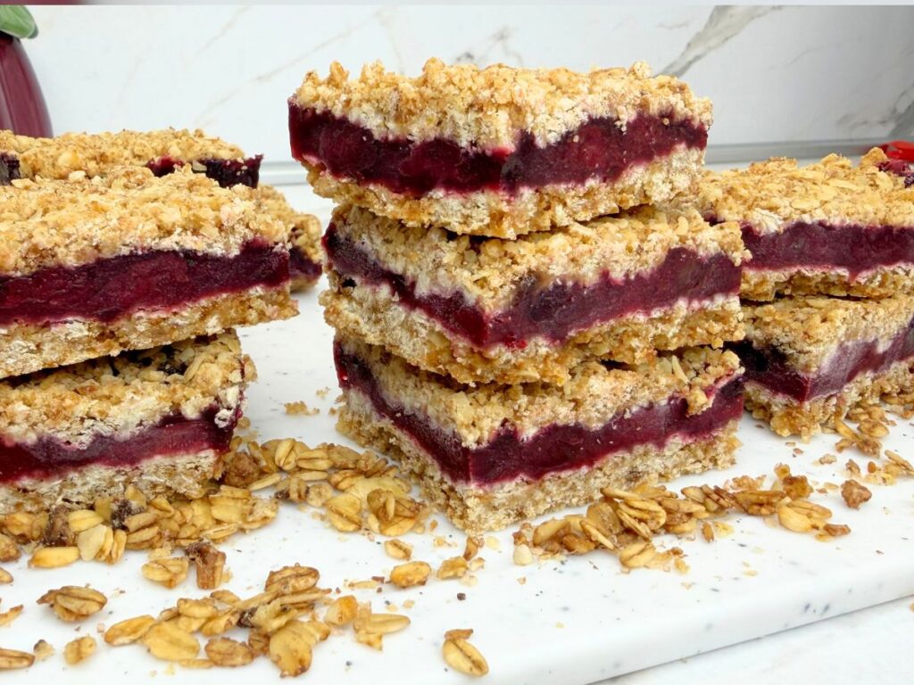Three stacked cherry crumb bars with a thick cherry filling and golden oat crumble topping.