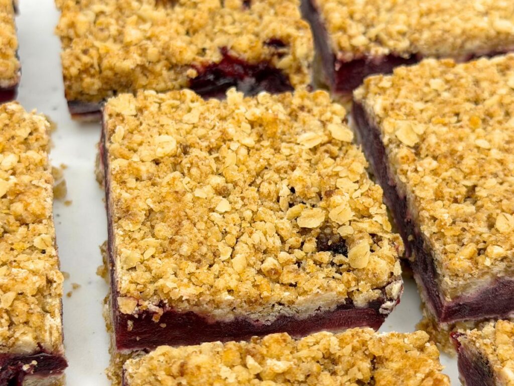 Freshly cut cherry crumb bars with a thick cherry filling and golden oat crumble topping.