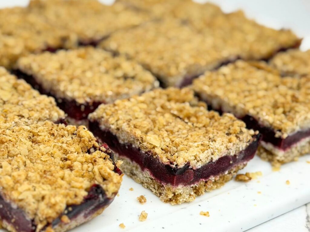 Freshly cut cherry crumb bars with a thick cherry filling and golden oat crumble topping.