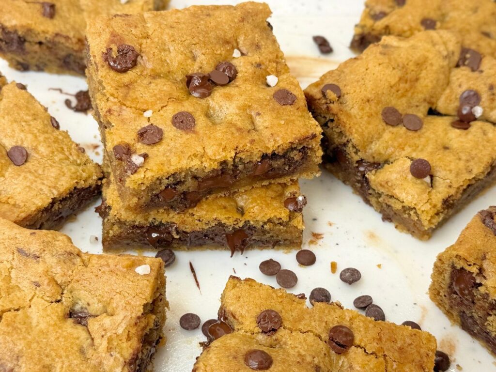 Soft and chewy chocolate chip cookie bars stacked with gooey chocolate chips.