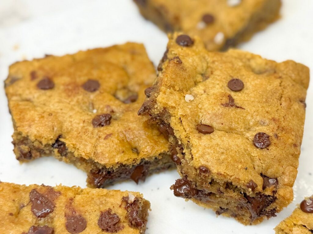Soft and chewy chocolate chip cookie bars stacked with gooey chocolate chips.