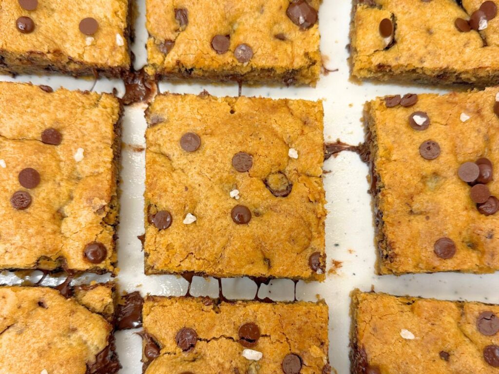 Soft and chewy chocolate chip cookie bars stacked with gooey chocolate chips.