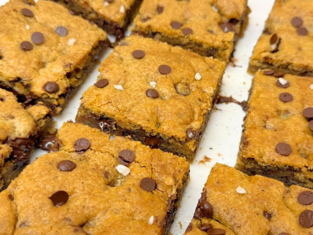 Soft and chewy chocolate chip cookie bars stacked with gooey chocolate chips.