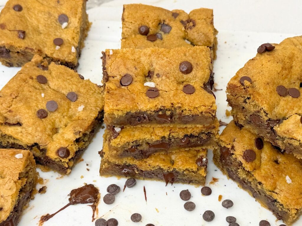 Soft and chewy chocolate chip cookie bars stacked with gooey chocolate chips.