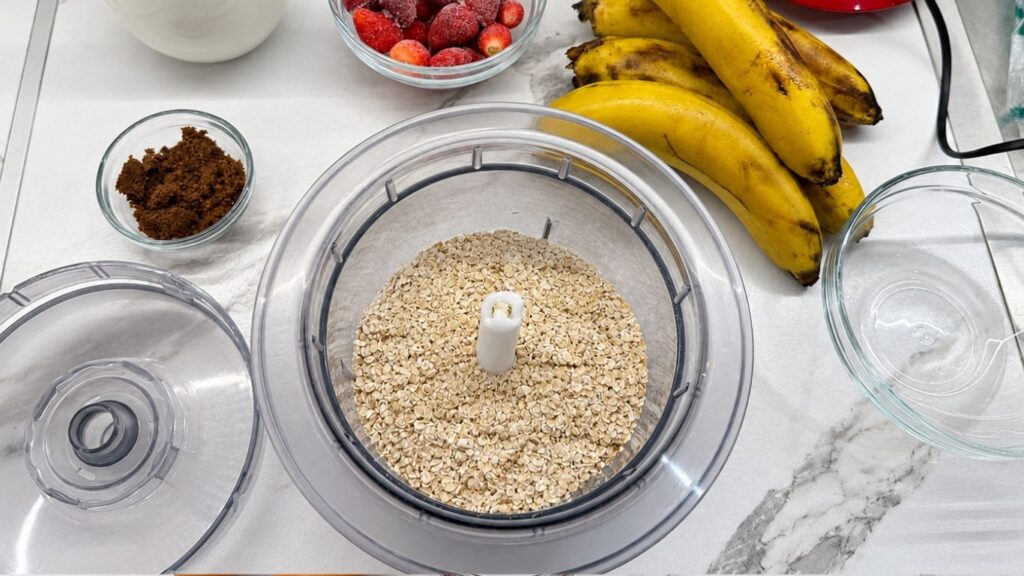 Gluten-free oats in a blender, ready to be ground for banana pancakes.