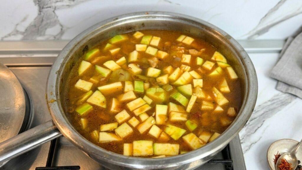 Pouring water or broth into the pot with all the combined ingredients for one-pot chicken and rice.