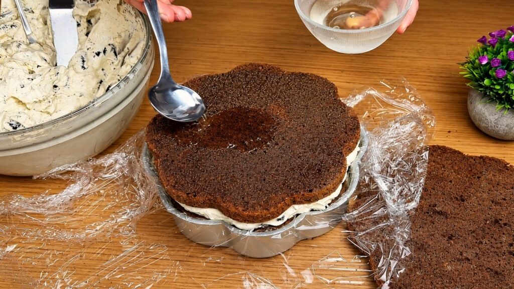 Brushing simple syrup onto a chocolate cake layer.