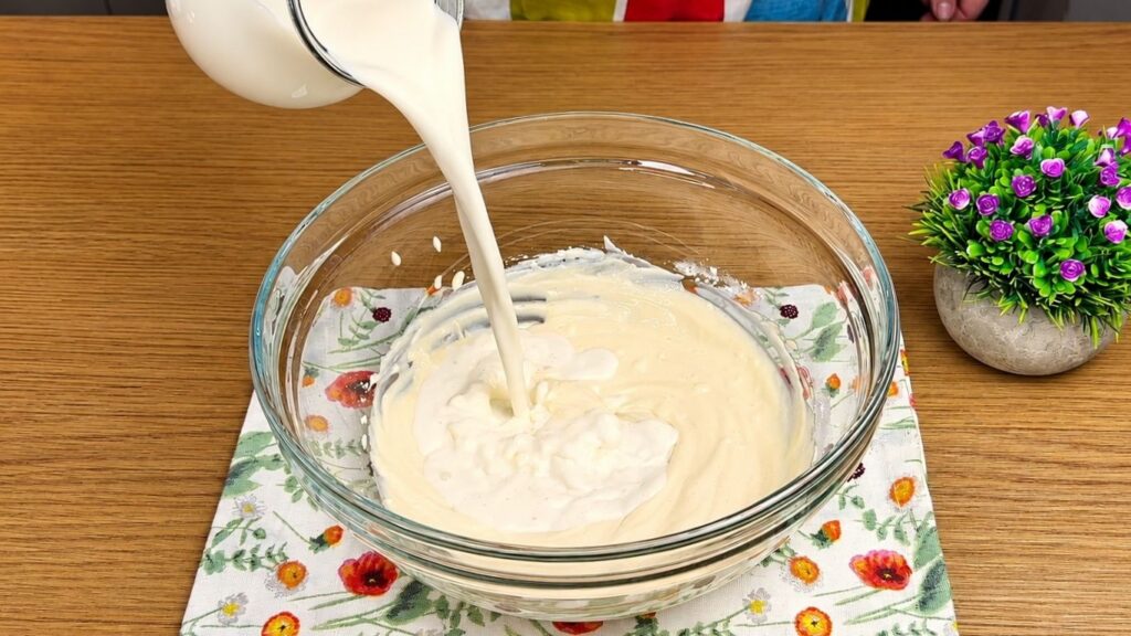Adding milk to the cream cheese mixture for Oreo filling.