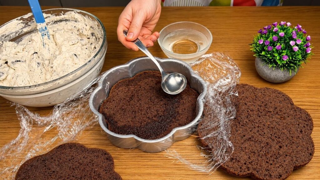 Brushing simple syrup onto a chocolate cake layer.