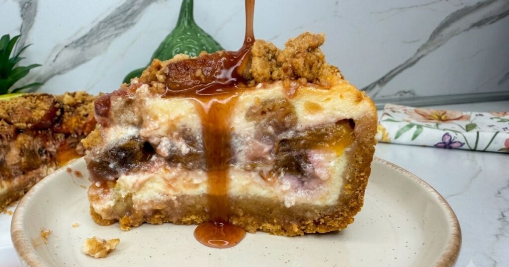 Slice of Peach Cobbler Cheesecake on a plate drizzled with sweet peach juice.