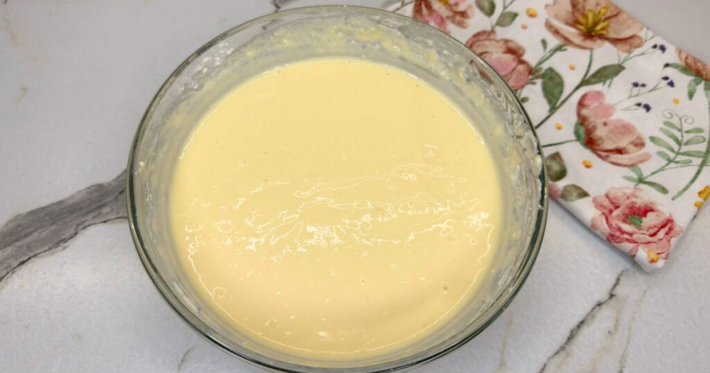 Creamy cheesecake filling mixed in a bowl for Peach Cobbler Cheesecake.