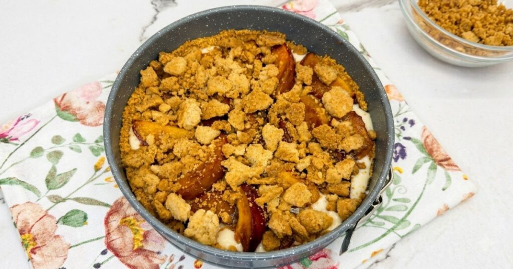 Baked crumble topping sprinkled over the peach layer in the Peach Cobbler Cheesecake.