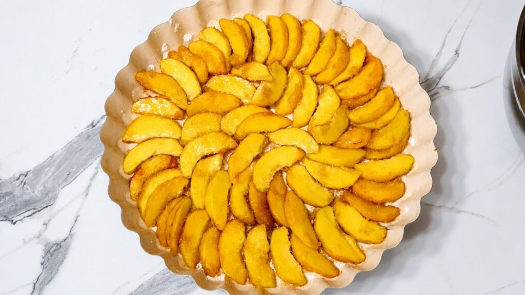 Fresh peach slices arranged in a circle in a baking pan for homemade peach upside down cake