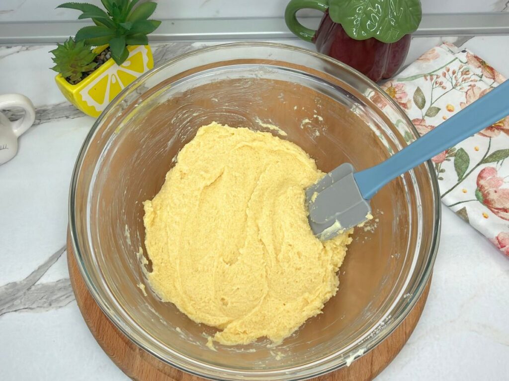 Creamed butter, sugar, and egg mixture in a bowl for raspberry sugar cookies.