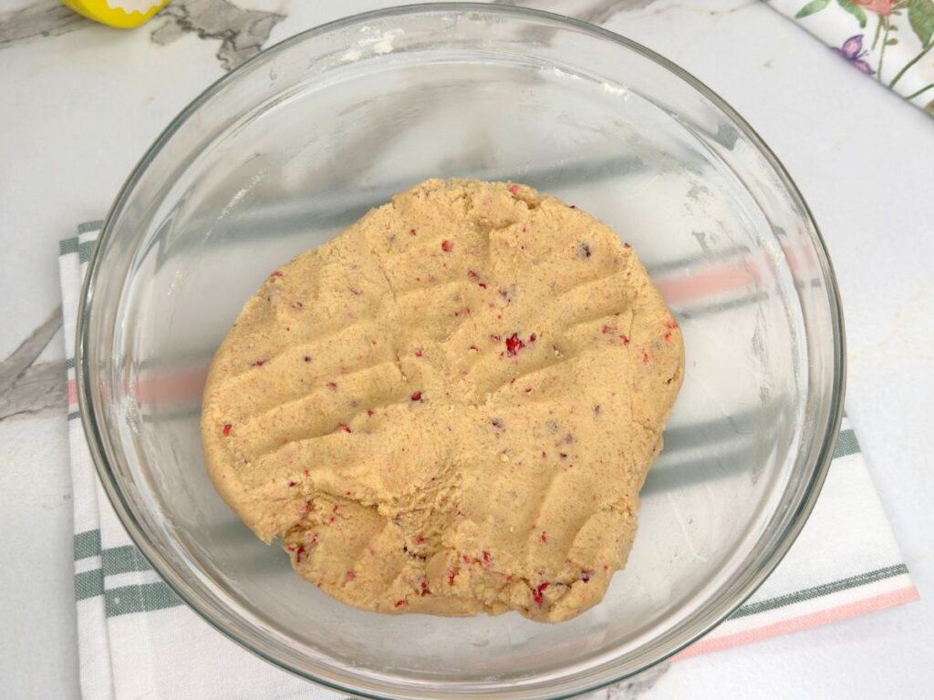Mixed raspberry sugar cookie dough in a bowl, ready to scoop and bake.