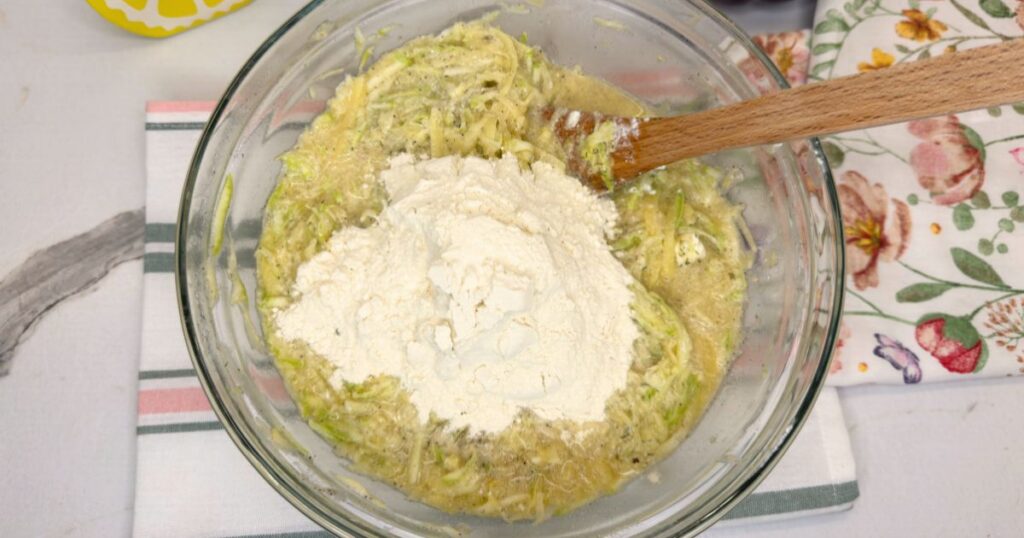 All ingredients for zucchini and potato slice combined in a large mixing bowl