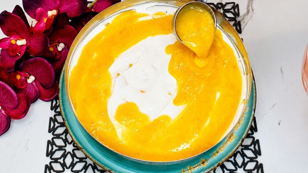 Pouring the peach topping over the chilled yogurt cream layer for easy no-bake peach yogurt cake.