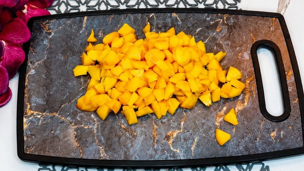 Fresh peaches chopped into small pieces on a cutting board for easy no-bake peach yogurt cake.