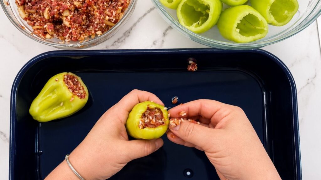 Filling bell peppers with ground beef and rice mixture for a homemade stuffed peppers recipe.
