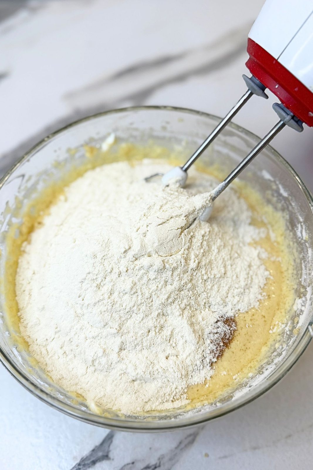 Dry ingredients being mixed into the wet ingredients for apple crumb muffin batter.