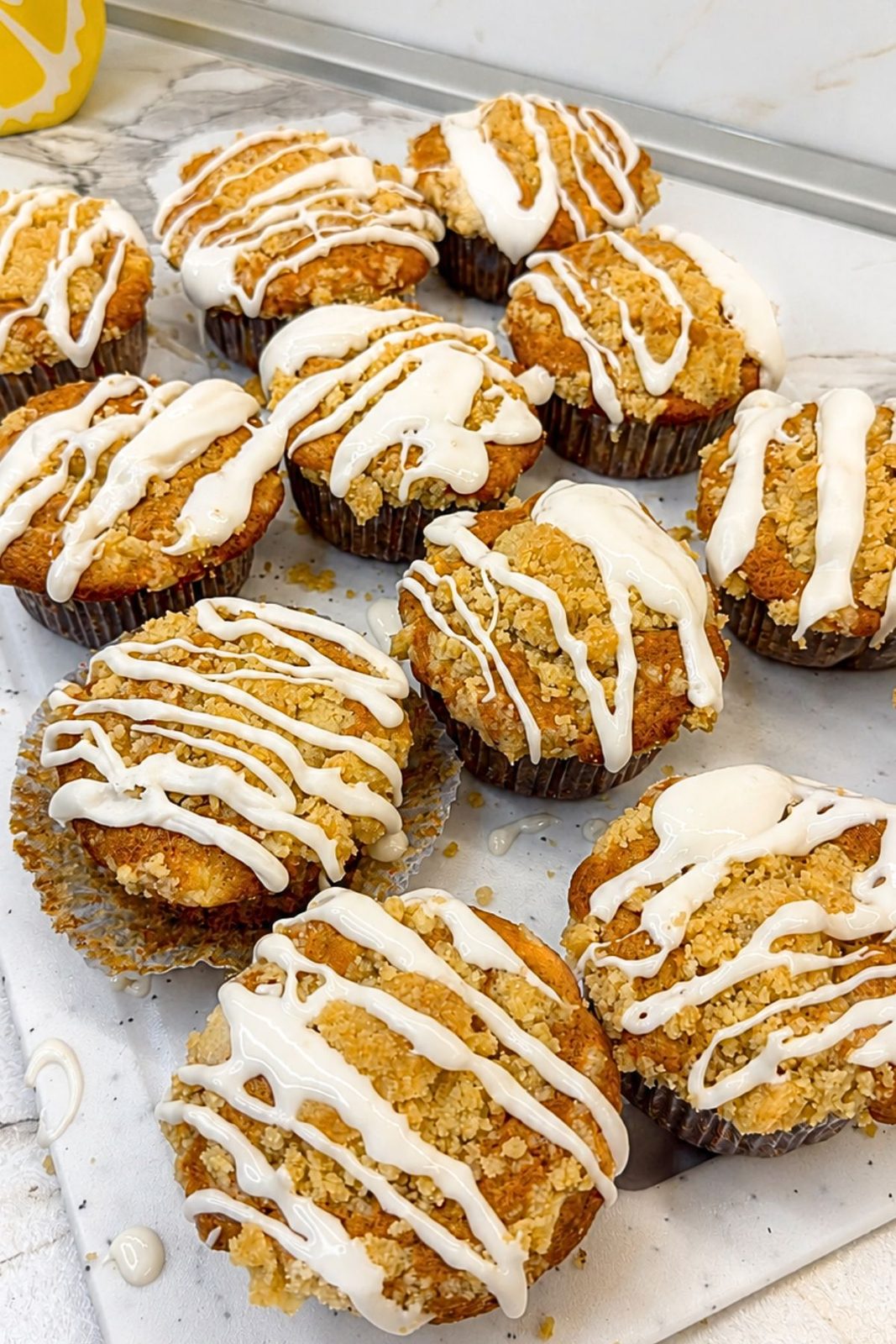 Apple crumb muffins finished with sweet vanilla icing after cooling.