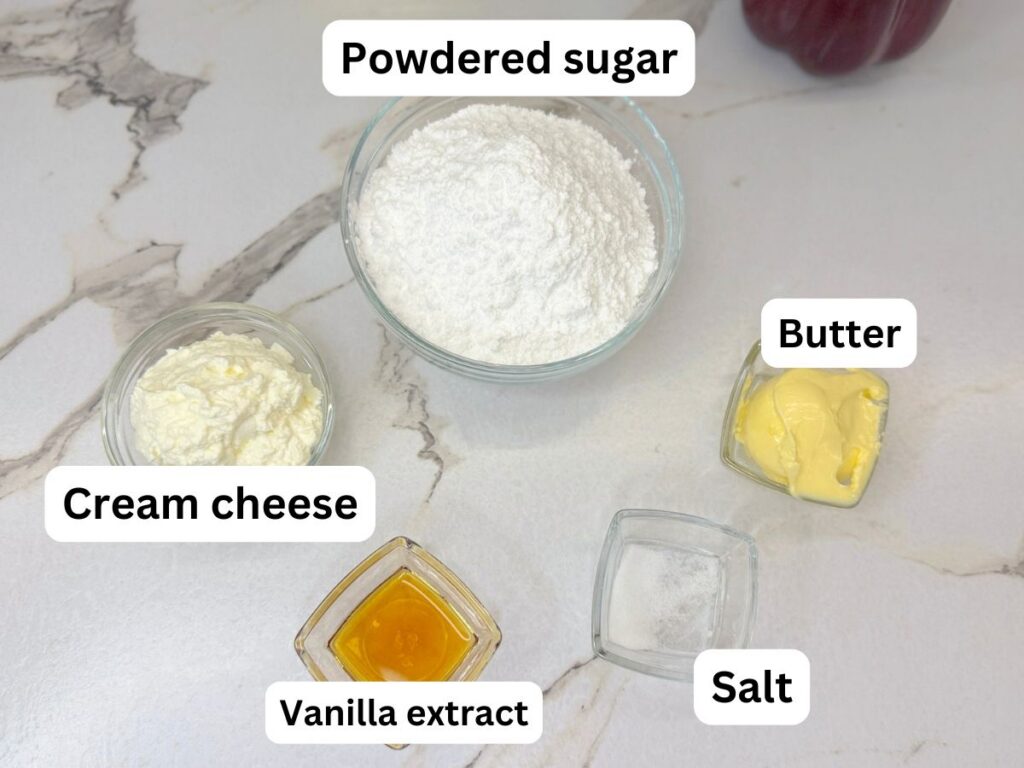 Banana cake ingredients arranged on a table, including ripe bananas, flour, butter, eggs, buttermilk, sugars, and cream cheese.