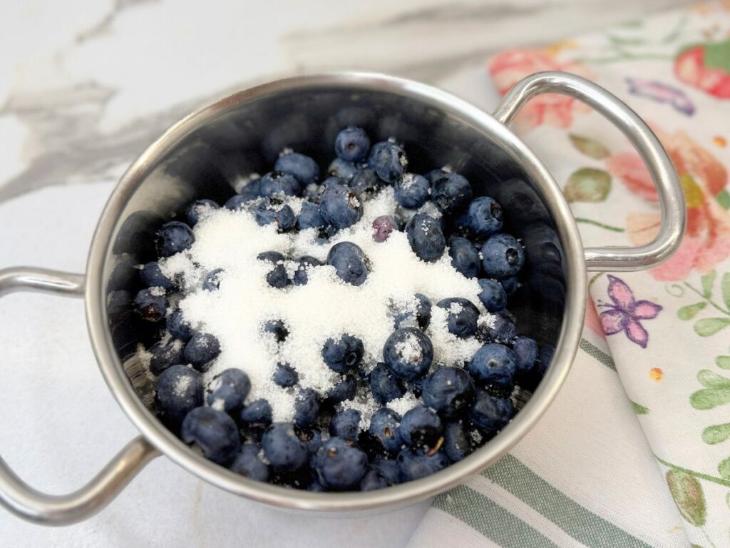 Fresh blueberries with sugar in a saucepan for homemade blueberry sauce